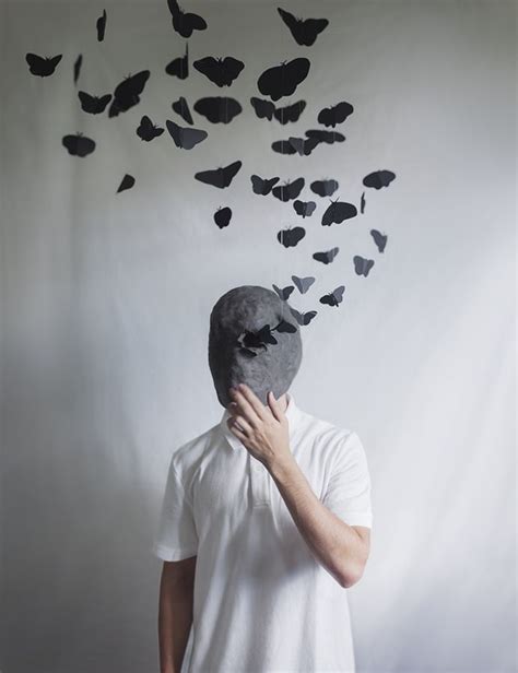 A Man With A Mask Covering His Face In Front Of A Flock Of Black
