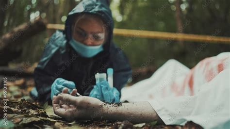 Coroner Ispecting A Dead Body And Taking Dna Samples From A Crime Scene