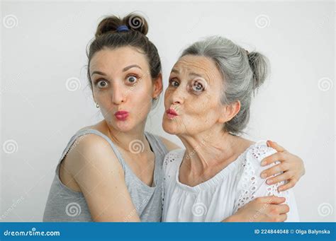 happy senior mother is hugging her adult daughter the women are laughing together sincere