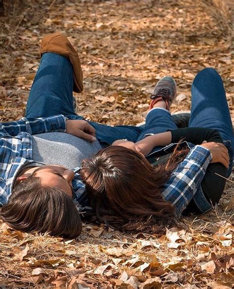 two people laying on the ground with their heads together