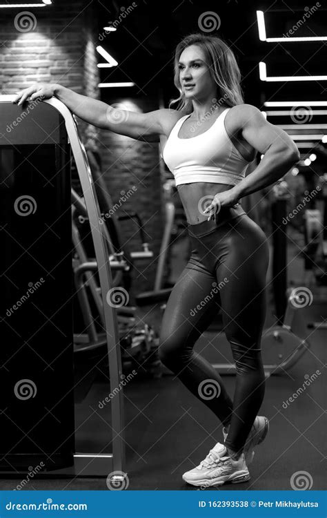 Blonde Bodybuilder Woman Is Sitting With Dumbbell In The Gym And Posing Bw Royalty Free Stock