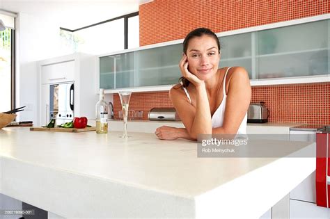 Woman Leaning Against Kitchen Counter Resting Chin On Hand Portrait