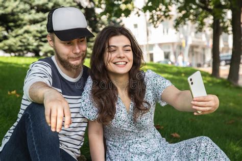 Un Chico Y Una Chica Se Toman Un Selfie Sentados En El Pasto En El