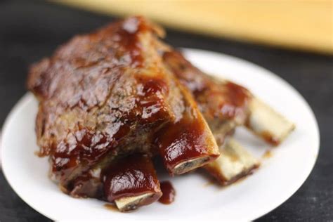 Ribs Covered In Bbq Sauce On A White Plate