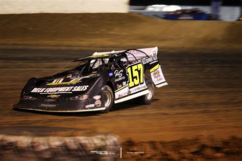 A Dirt Racing Car Driving Around A Track