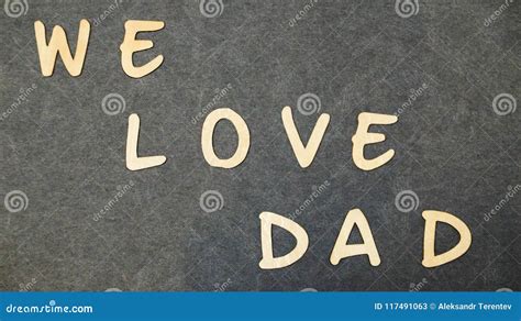 The Inscription We Love Dad Folded Of Wooden Letters On A Black