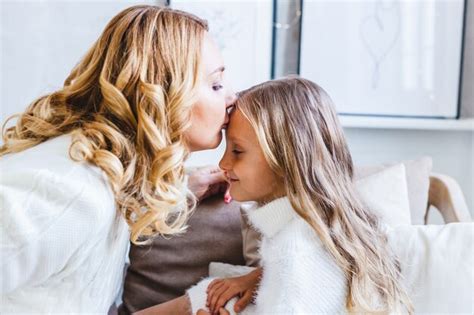 Premium Photo Mother Kisses Daughter On Her Forehead