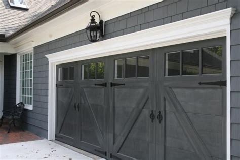A Gray Garage With Two Doors And Windows