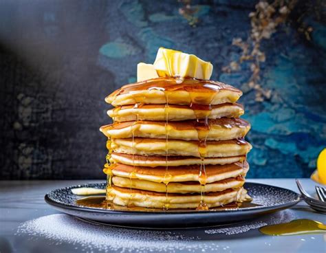 Premium Ai Image The Tall Stack Of Huge Fluffy Pancakes Covered In Maple Syrup And Butter