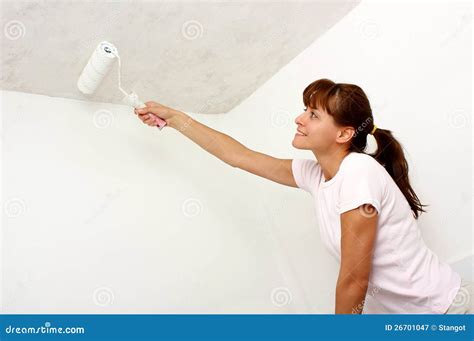 Woman Painting Wall With Paintroller While Standing On Stepladder Stock