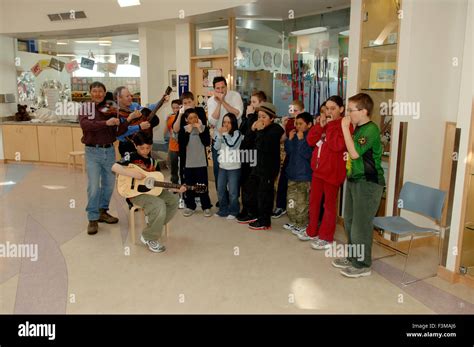 Musician Mike Stevens And School Kids Playing Harmonica And Guitar