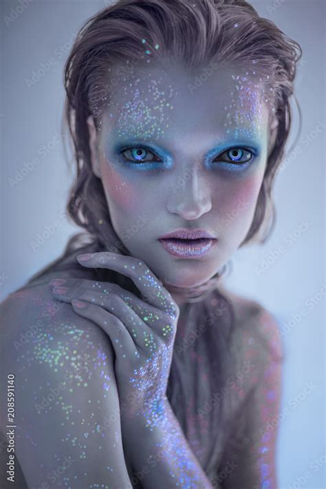 Portrait Of Alien Woman With Glitter Make Up Looking At Camera Stock