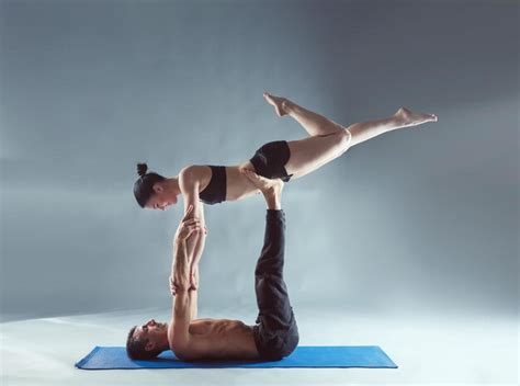 Premium Photo Young Couple Practicing Acro Yoga On Mat In Studio