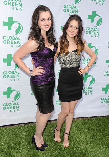 Two Women Standing Next To Each Other On A Green Carpet