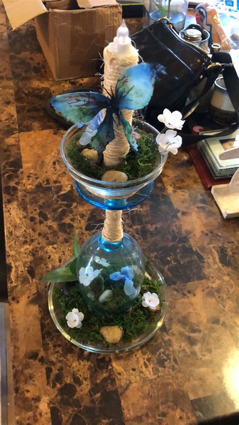 Two Glass Vases With Plants And Rocks In Them