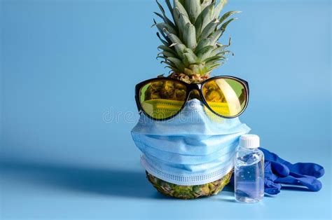 Pineapple With A Medical Mask And Sun Glasses On The Blue Background