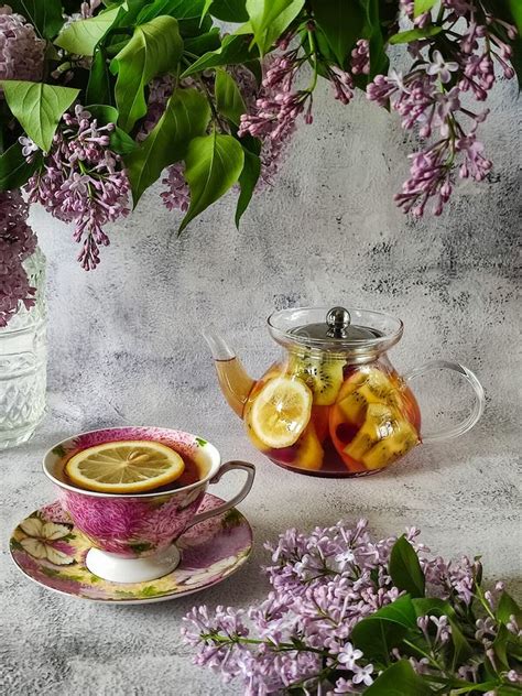 Beautiful Still Life With Fruit Tea And Lilac Branches Stock Photo