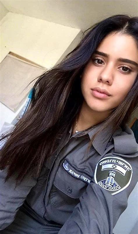 A Woman With Long Dark Hair Wearing A Police Uniform And Posing For The