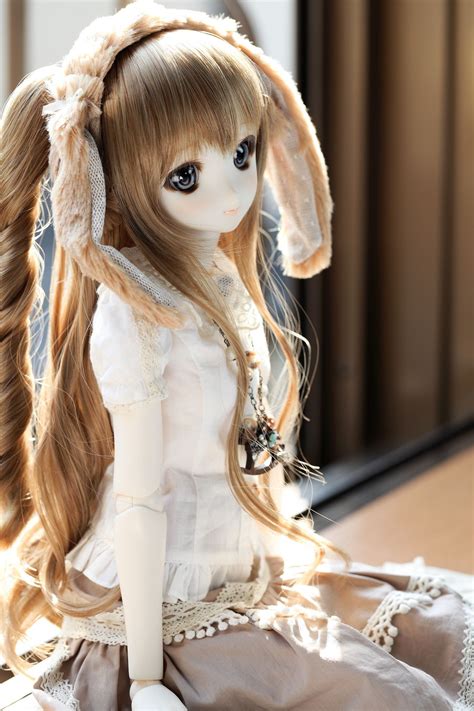 A Doll Is Sitting On The Floor With Long Hair And Wearing A White Dress
