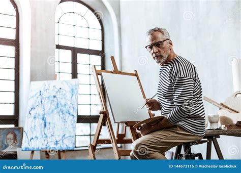 Professional Famous Artist Sitting And Painting In Big Workshop Stock