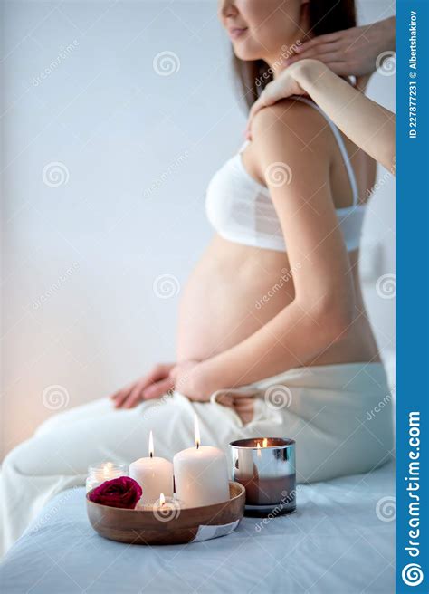 Pregnant Woman Receiving Back Massage From Masseur In Spa Cabinet Sit With Candles Stock Image