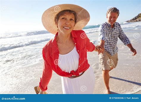 Theyre A Fun Loving Couple A Mature Couple Enjoying A Late Afternoon Walk On The Beach Stock