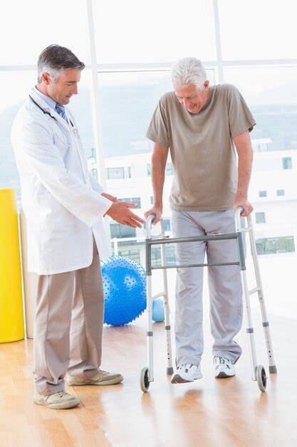 Premium Photo Senior Man On Zimmer Frame With Therapist