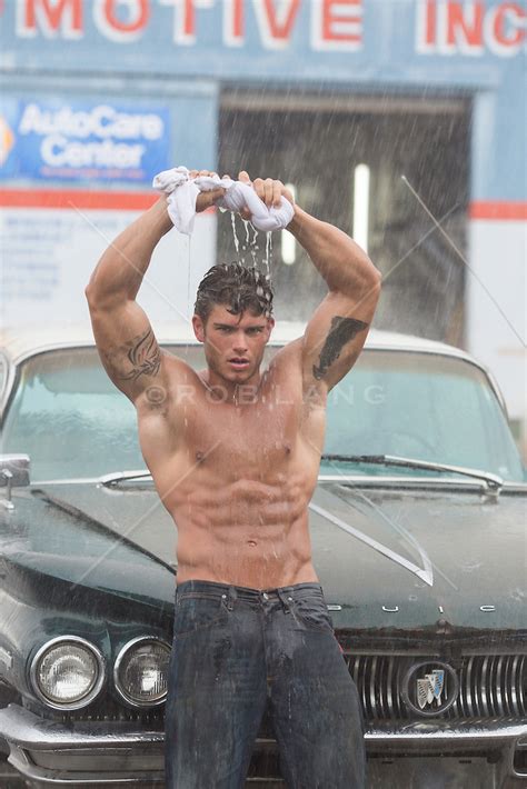Shirtless Muscular Man In The Rain Wringing Out His Shirt Over His Head ROB LANG IMAGES