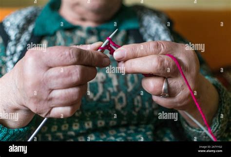 Old Woman Knitting In Home Near The Window Selective Focus Stock Photo