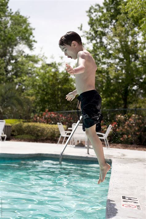Boy Jumps Into A Swimming Pool While On Vacation Del Colaborador De