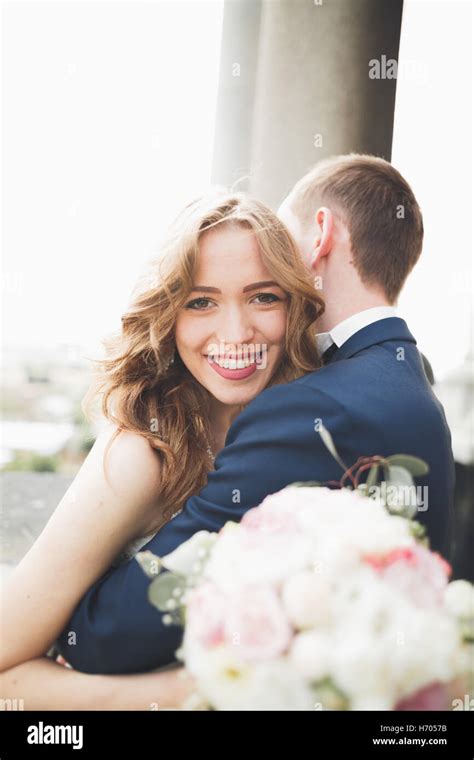 Stylish Beautiful Wedding Couple Kissing And Hugging On Background