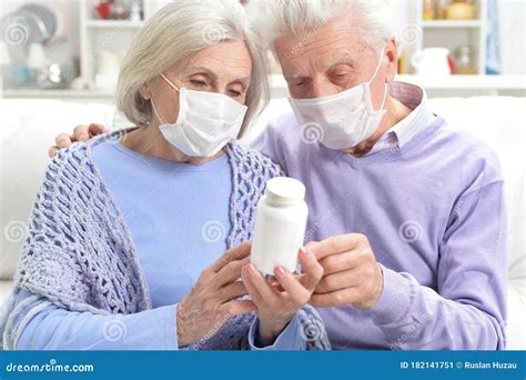 sick elderly woman and man with facial masks holding pills stock image image of caucasian