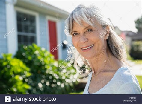 Portrait Smiling Senior Woman In Sunny Front Yard Stock Photo Alamy