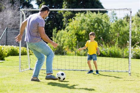 Father And Son Playing Football In The Park Stock Photo Image Of Lawn