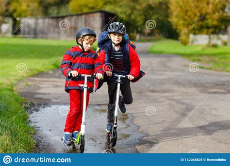 But if it's raining heavily and your visibility is reduced, you probably shouldn't go riding. Two Little Kids Boys Riding On Push Scooters On The Way To ...