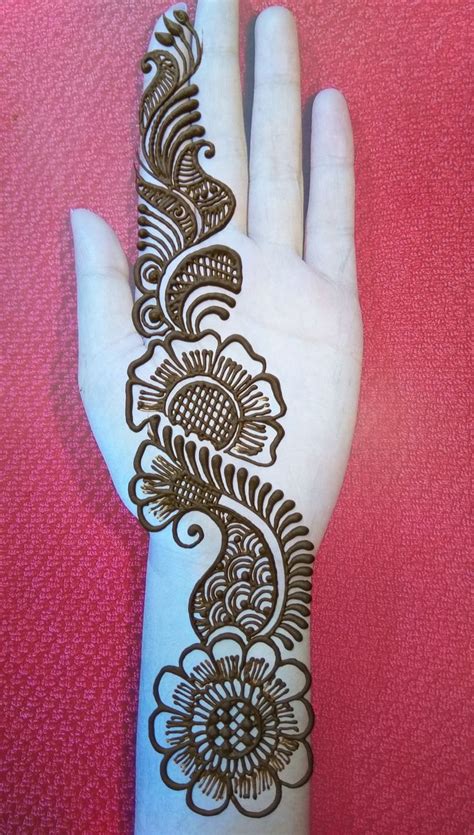 A Hand With Henna On It That Is Sitting On A Pink Surface And Has An