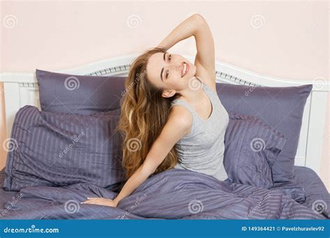 Beautiful Young Woman Stretching After Waking Up While In Cozy Bedroom Bed Smiling Rested Girl