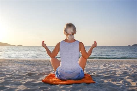 Meditación De La Mujer En Una Pose De Yoga En La Playa Foto Premium
