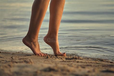Female Feet Barefoot On A Sandy Beach In The Water Close Up Of Beautiful Female Legs Wet Foot