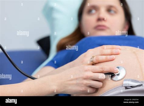 Close Up View Of A Lady Doctor Auscultating A Pregnant Womans Abdomen With A Stethoscope