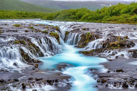 Bruarfoss Waterfall In The Summer With Trees And Green Grass All Over