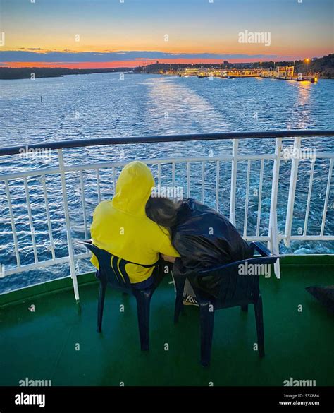 A Romantic Couple Sit Together Staring Back At The Island Of Åland As A