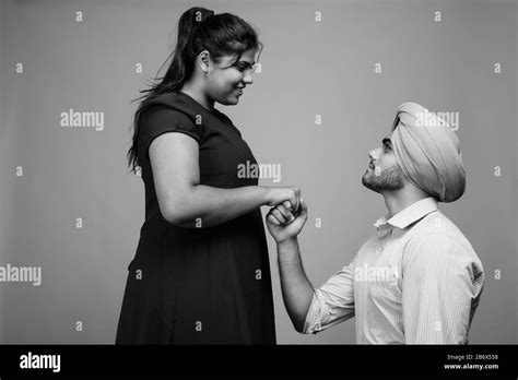 Young Indian Couple Together And In Love Against Gray Background Stock