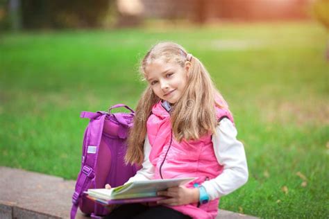 Schoolgirl With A Backpack And Book Outdoors Education And Learning