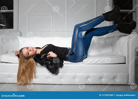 Alluring Woman Posing Lying On A Sofa Stock Image Image Of Jeans