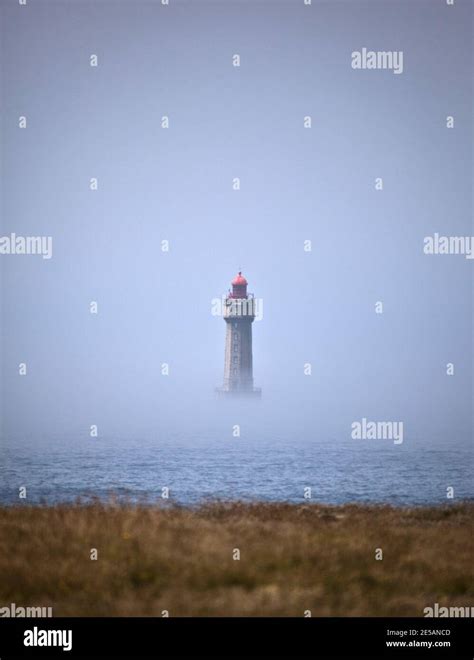The Dramatic La Jument Lighthouse Shrounded In Summer Fog Off The
