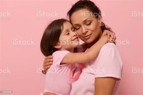 Beautiful Loving Mother And Daughter Hugging Each Other Wearing Pink