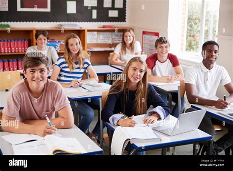 Portrait Of Students Sitting At Desks In Classroom Stock Photo Alamy