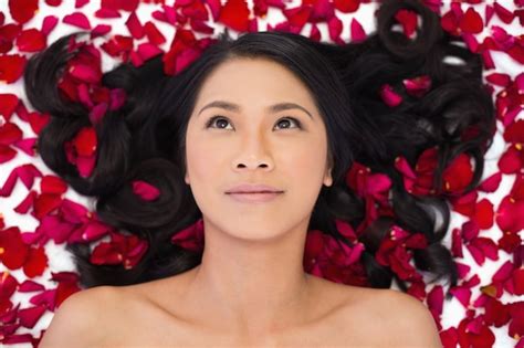 Premium Photo Pensive Sensual Dark Haired Model Lying In Rose Petals