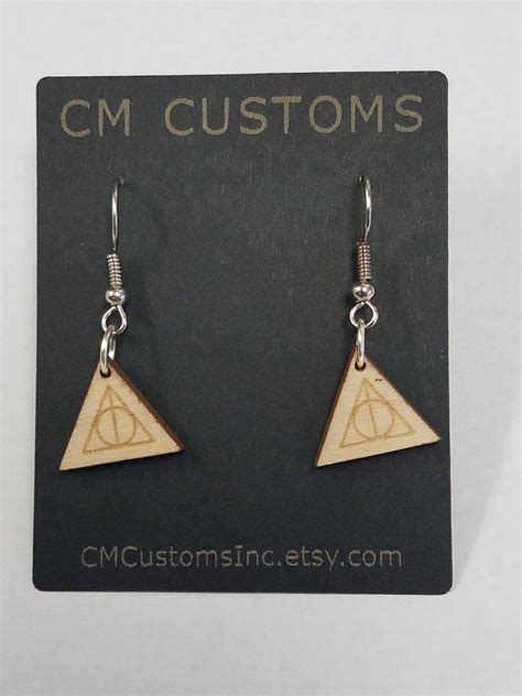 The Earrings Are Made Out Of Wood And Have Harry Potters Symbol On Them